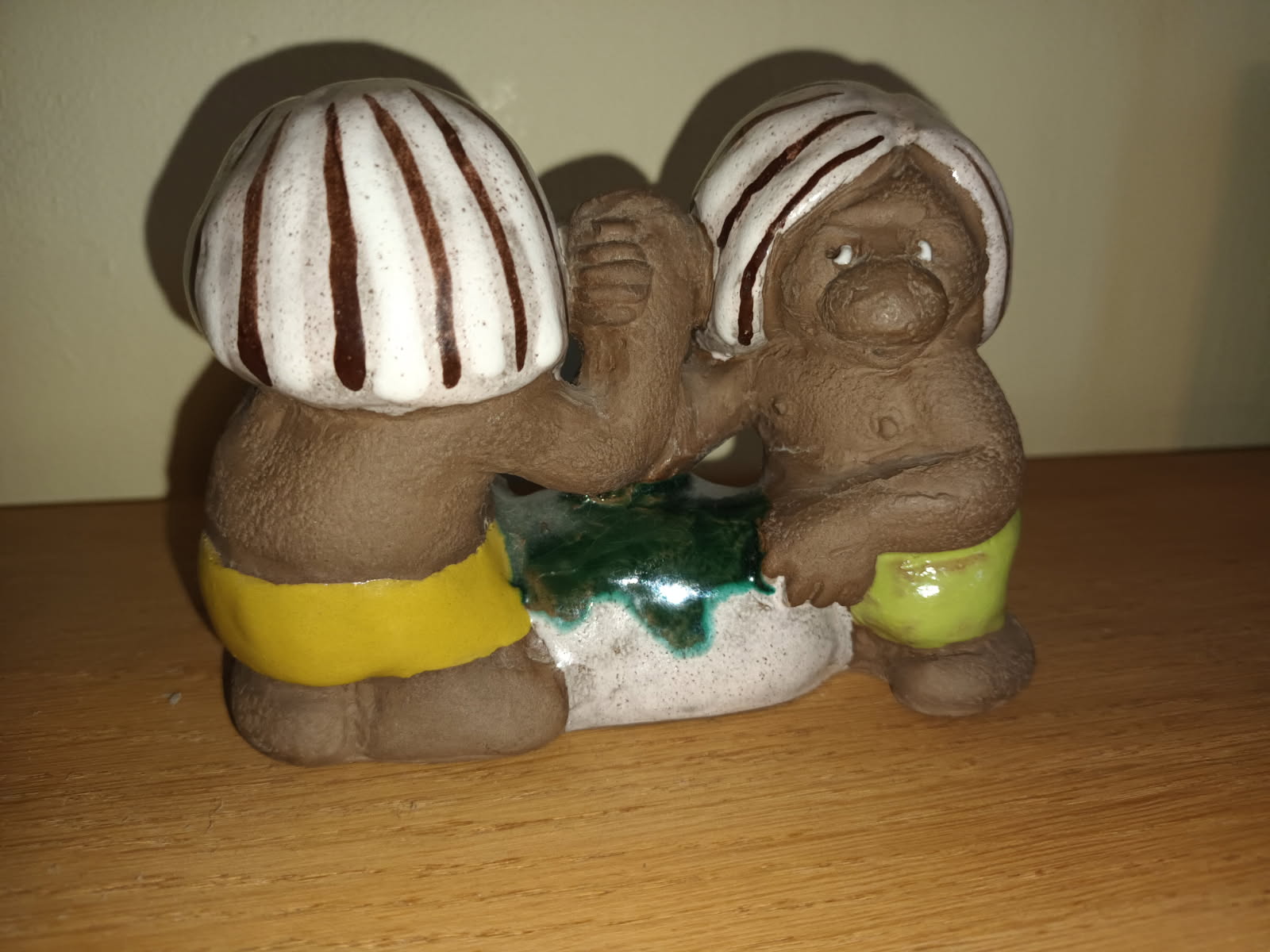 Två keramiktroll som bryter arm